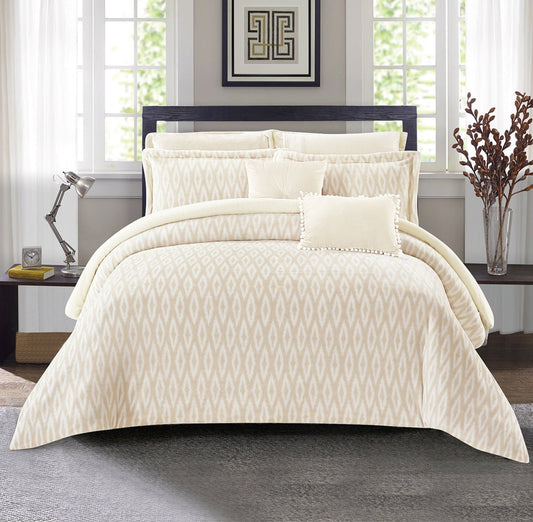 A beige floral fleece comforter set on a king-sized bed, with additional bedding pieces and decorative pillows displayed in a bedroom setting.