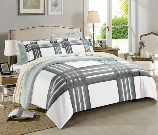 A reversible striped and print comforter set displayed on a bed in a bedroom setting, with a striped pattern on one side and a solid color on the other.