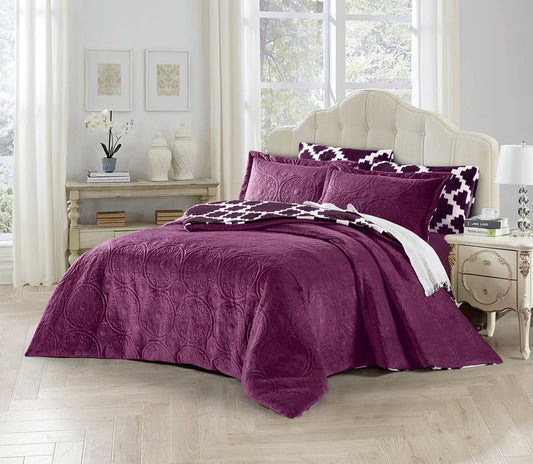 A purple comforter set on a bed with additional decorative pillows and a duvet cover, in a bedroom setting.