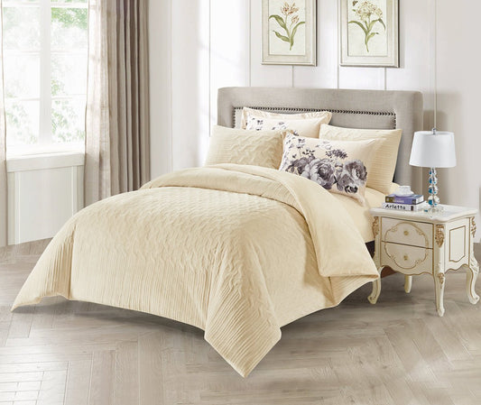 A beige embossed stripe comforter set displayed on a bed, with additional decorative pillowcases placed on the bed and a nightstand beside the bed.
