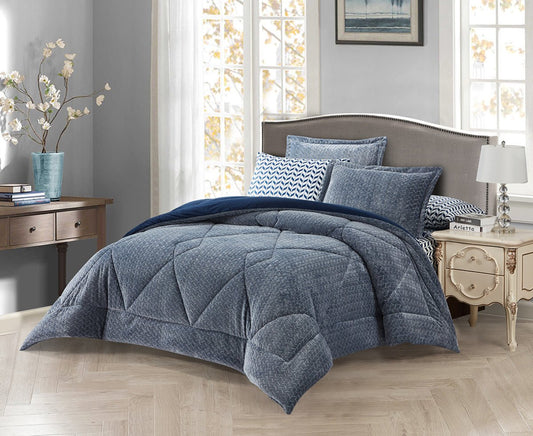 A charcoal grey quilted bedding set on a king-sized bed, with two additional pillows on the bed, placed in a room with a nightstand and a lamp on either side of the bed.