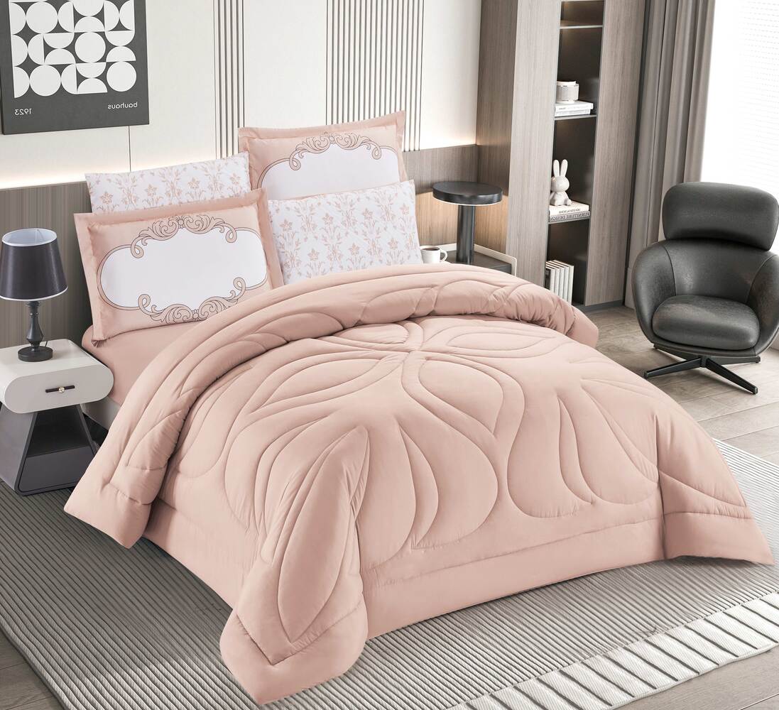 A blush pink quilted bedding set with a 3D diamond stitch design displayed on a bed, including two pillowcases.