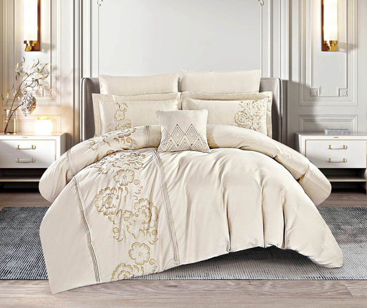 A beige jacquard quilt set displayed on a bed, with ornate floral patterns on the comforter and pillows.