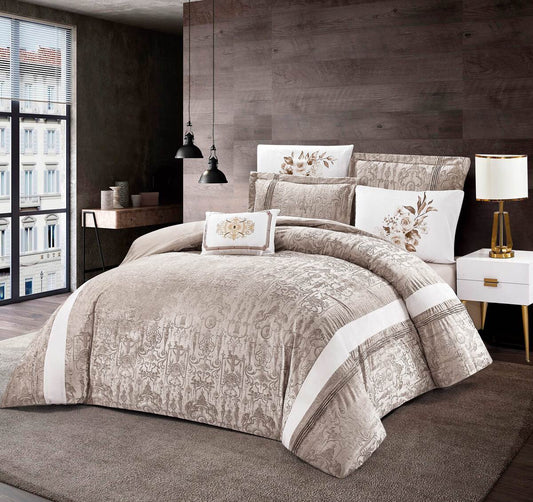 A luxury beige and white patchwork embossed comforter set displayed on a bed, with decorative pillowcases and a bed skirt, in a room with wooden walls and a chandelier.