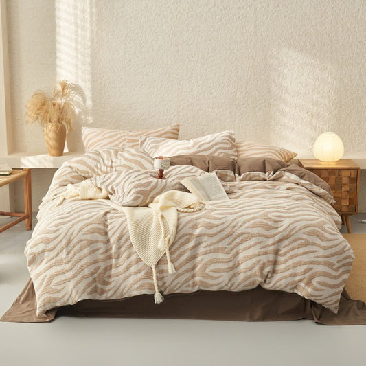 A beige and white zebra jacquard washed cotton duvet cover set on a bed, with additional pillows and bedding arranged neatly beside the bed.