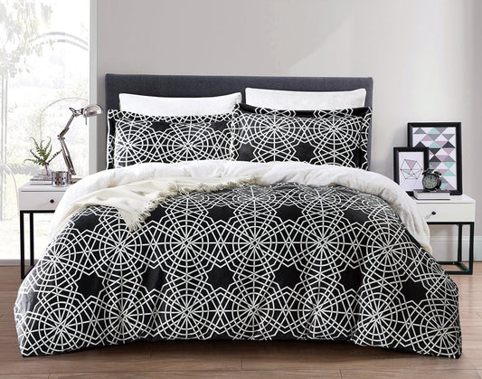 A black and white printed bedding set on a bed, with a full-length mirror and a picture frame on the wall in the background.