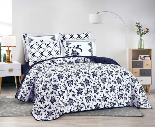 A reversible bedspread with a floral pattern on one side and a geometric pattern on the reverse, displayed in a bedroom setting with matching pillows, bed frame, and decor.
