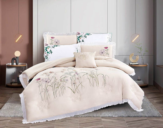 A beige comforter set with floral lace detailing, displayed on a bed in a stylish bedroom setting with bedside tables and lamps.