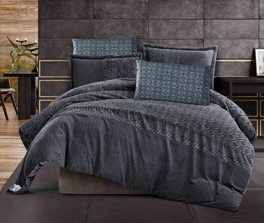 A charcoal gray quilted color-block comforter set with geometric stitch design displayed on a bed, accompanied by matching pillows.