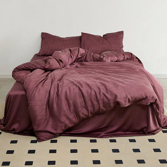 A purple satin-tencel jacquard duvet cover set on a bed with matching pillows and bed sheet.