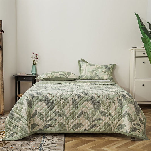 A green floral patterned cotton duvet cover set on a bed, with matching pillows, in a bedroom setting.