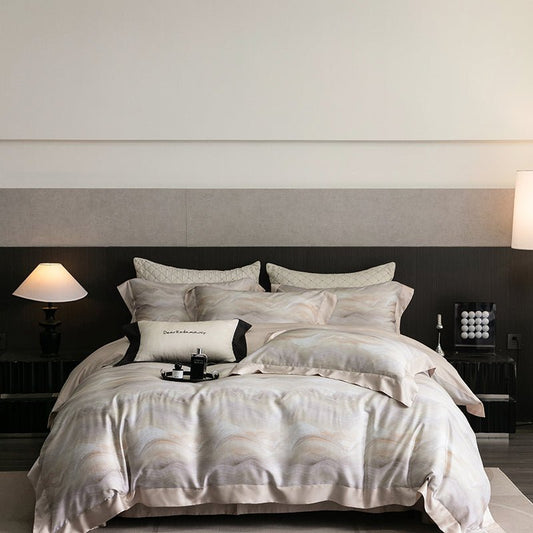 A printed bedding set on a bed, with a variety of pillowcases and a duvet cover in a geometric pattern, placed in a room with bedside tables and lamps.