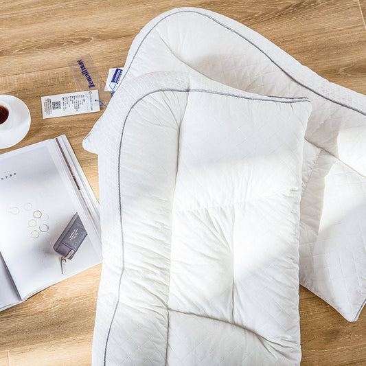 A white adjustable cervical support brace laid out on a wooden floor, with packaging and a measuring tape nearby.