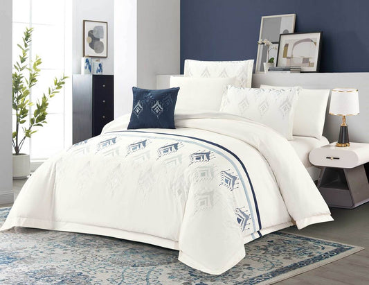 A cream-colored bedding set with blue patterns, displayed in a room setting, including a comforter, pillows, and a bedsheet.