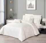 A cream-colored lace bedding set on a bed, with matching pillows and comforter, in a bedroom setting.