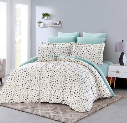 Bed with floral comforter and light blue pillows in a bedroom setting.
