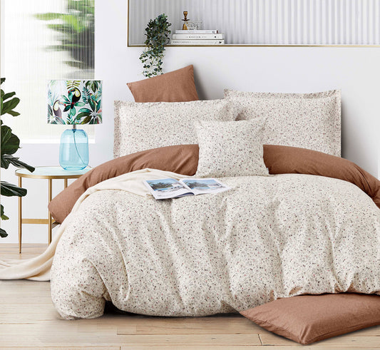 Neatly made bed with beige and brown bedding in a well-lit bedroom.