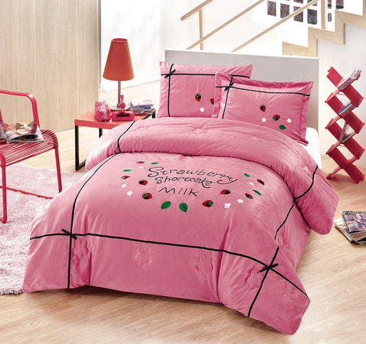A pink bedding set with embroidered text and a milk and strawberries design, displayed in a bedroom setting with decorative pillows, bed sheet, and comforter.
