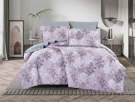 A bedding set with a floral pattern in purple and gray colors, displayed on a bed with a wooden floor and a framed picture on the wall.
