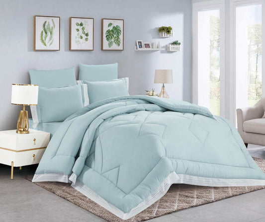 A quilted comforter set with lace trim, displayed on a bed in a bedroom setting. The bedding set is in a light blue color and includes matching pillows.