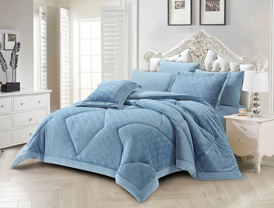 A sky blue floral quilted bedding set on a bed, with additional pillows and comforter visible, presented in a bright room setting.