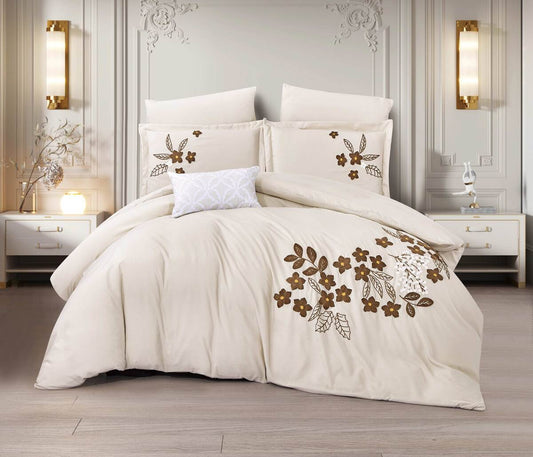 A white bedding set with embroidered floral patterns, displayed in a stylish bedroom setting with elegant decor in the background.