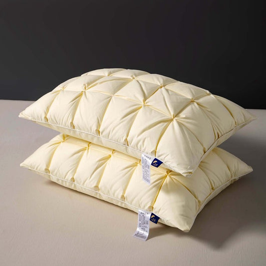 Two white goose down pillows with a pinched or pleated design, placed one on top of the other.