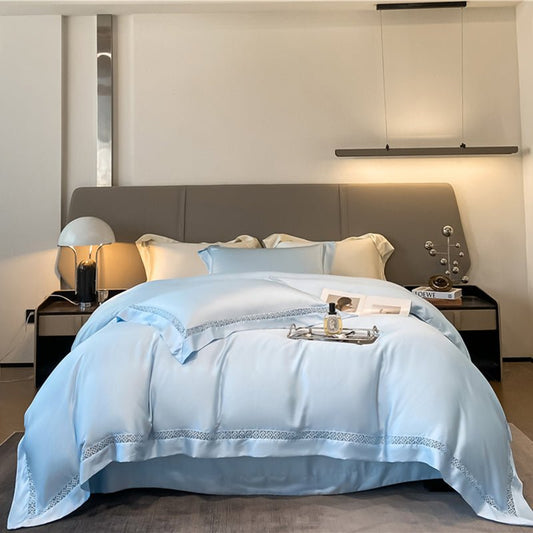 A blue duvet cover with lace trim, displayed on a bed in a bedroom setting.