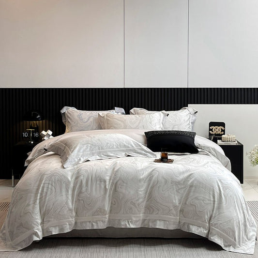 A luxury shadow-weave cotton duvet cover set in white, displayed on a bed with matching pillows and bedsheet, in a room with modern decor.