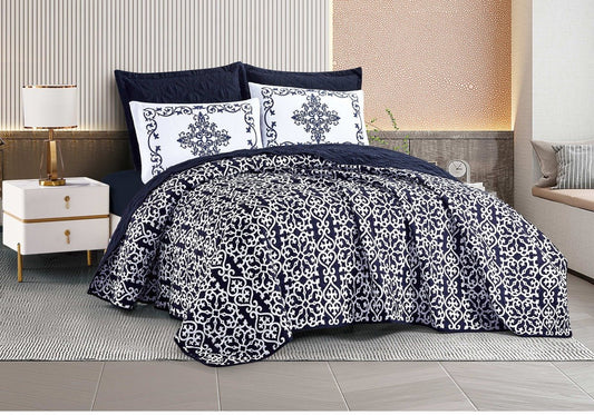 A navy botanical print bedding set displayed on a bed, with matching pillows and comforter.
