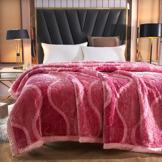 A red and pink tartan print blanket draped over a bed in a bedroom setting with decorative pillows, a wooden headboard, and a lamp on each side of the bed.