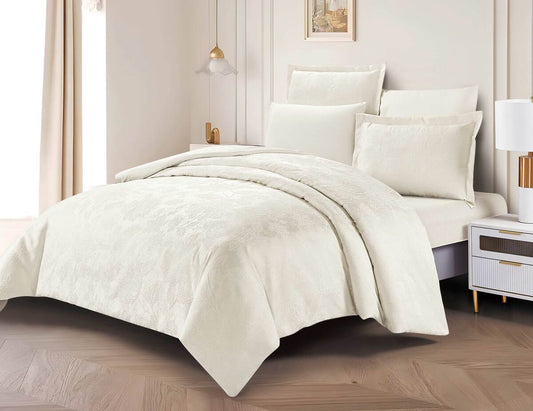 A cream floral bedding set on a bed, with matching pillows and comforter, in a room with wooden flooring and a light interior.