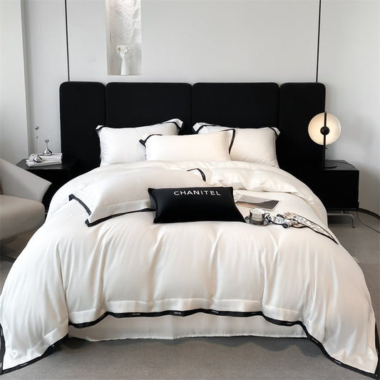 A white Tencel duvet cover set on a bed with black accents, displayed in a modern bedroom setting.