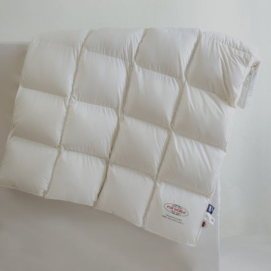 A white, single-layer down mattress topper with a quilted design, displaying the brand label Øksteds on the bottom right.