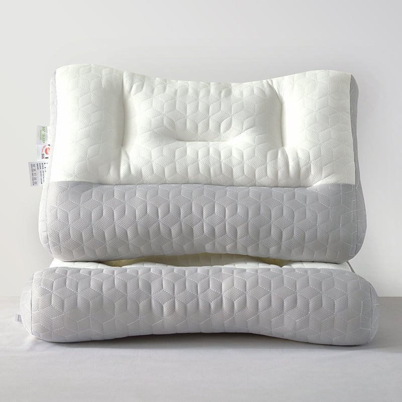 A stack of white and gray zoned latex pillows with textured surfaces.