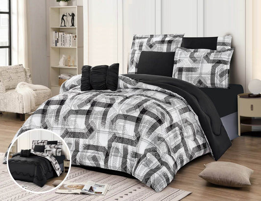 A reversible printed summer comforter set in black and white with a geometric pattern, displayed on a bed in a room. The set includes a comforter, pillows, and a bed sheet.