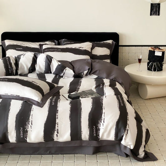 A duvet cover set with a geometric black and white design, displayed on a bed with bedding and pillows.