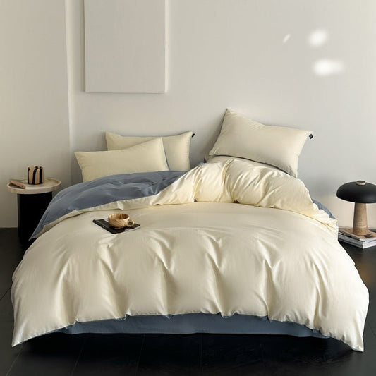 A luxury bedding set in beige and blue colors, displayed on a bed with pillows and a comforter.