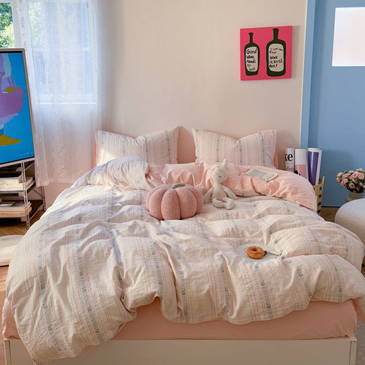 A striped duvet cover set on a bed in a bedroom setting, with a variety of colors including white, pink, and blue.