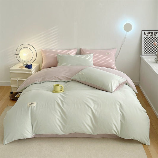 A duvet cover set in beige and pink colors, displayed on a bed with a modern room setting.