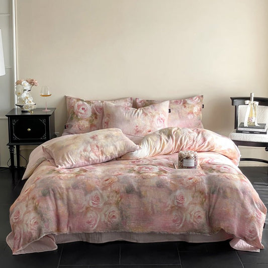 A pink floral duvet cover set on a bed, with additional pillows and a remote control on the bed's footboard.