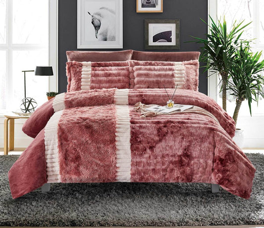 A color block comforter set in red and white, displayed on a bed with additional decorative pillows and a plant in the background.