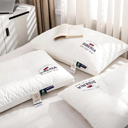 A set of white pillows with the brand name visible on them, displayed in a bedroom setting.