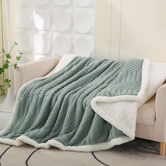 A green fleece blanket with a polka dot pattern on a sofa.