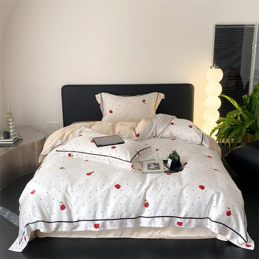 A duvet cover set with a white background featuring red rose and polka dot pattern, displayed on a bed with bedding and pillows.