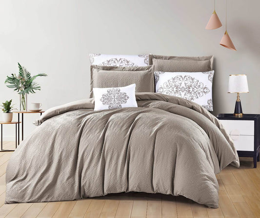 A bedding set in a mocha color with floral patterns on the pillows, displayed on a bed in a room with bedside tables and lamps.