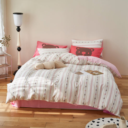 A duvet cover set with a bear motif, featuring a striped pattern in a bedroom setting.