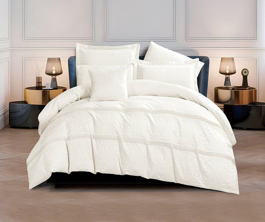 A white reversible comforter with a cut-out design, displayed on a bed in a room with shabby chic decor.