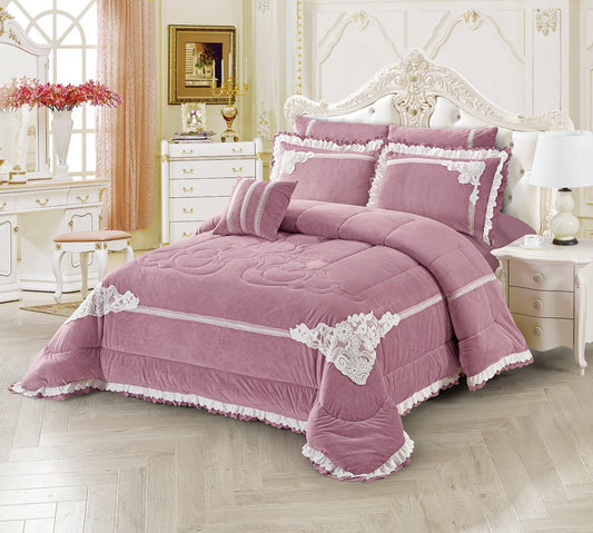 A blush pink comforter set with lace trim, displayed on a bed in a room with elegant decor.