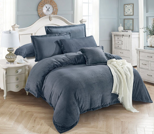 A gray winter comforter set on a bed with matching pillows and a comforter draped over the edge of the bed, in a room with wooden flooring and a traditional decor style.
